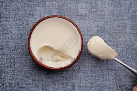 新鲜的酸奶在碗里 在餐桌上高架奶油养分白色节食勺子牛奶奶制品营养小吃背景图片