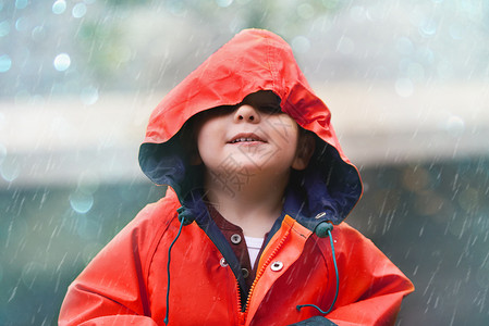 就选我如果你觉得天气凉爽 就来看我 有个可爱的小男孩在雨中在外面玩耍背景