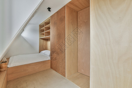 小桌子一间小卧室 有一张床和一堵木墙背景