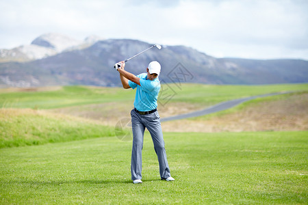 老高尔夫球手一个年轻的男性高尔夫球员在山周围的高尔夫球场的 飞道上练习挥杆 这是很完美的背景