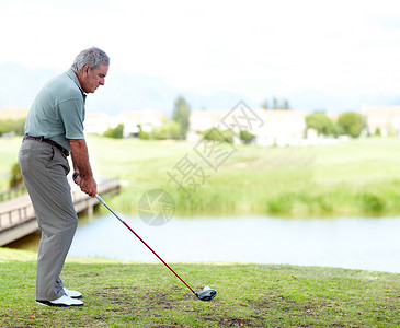 老高尔夫球手高尔夫球是思想的游戏 一个高年级男子专注在打高尔夫球场背景