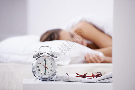 8小时睡眠一个女人睡在床上 前台有闹钟 - 她的床被关了8小时背景