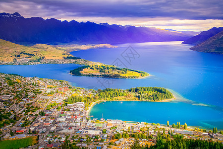 奥基提新西兰南部岛的皇后镇和瓦卡提普湖上方 日落时新西兰风景摄影全景湖岸鸟瞰图高山蓝色山脉海滩旅游背景