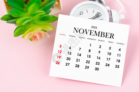11月月历2023年11月的月历为2023年 有粉色背景的老式闹钟背景