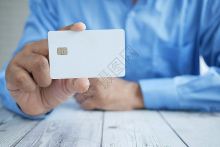 持有信用卡的手持信用卡者近亲芯片支付购物货币展示商业信用金融储蓄财富背景图片