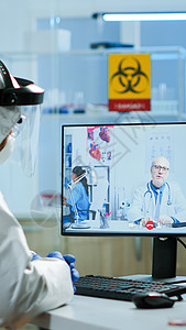 通过视频电话监听专业医生的录像电话 在Pee suit中进行切化师会议防护化学套装工作服电脑实验室药品团队研究员背景