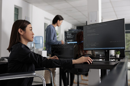 大数据web界面坐在轮椅上的 Web 开发人员在大数据办公室进行服务器编码背景