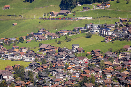 穿龙薯蓣瑞士瑞士阿尔卑斯山红列车和穿肩村假期村庄小木屋铁路运输天际高地机车火车房子背景