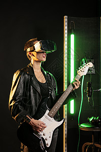 虚拟摇杆素材女演员在音响演播室电吉他演奏时身戴Vr护目镜以模拟音乐会背景