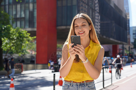 马斯普巴西圣保罗保利斯塔大街阳光明媚的日子里 巴西女孩使用手机应用聊天互联网晴天拉丁大街女士照片消息商业马路阅读背景