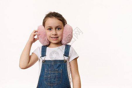 毛绒耳罩快乐的孩子 可爱的小女孩 戴着可爱的粉色冬日耳罩 — 毛绒耳机 可爱地笑着看着镜头背景