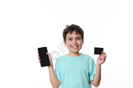 可爱的青少年对着镜头笑笑快乐 展示智能手机和黑信用卡 有免费版面宣传文字的空间背景图片