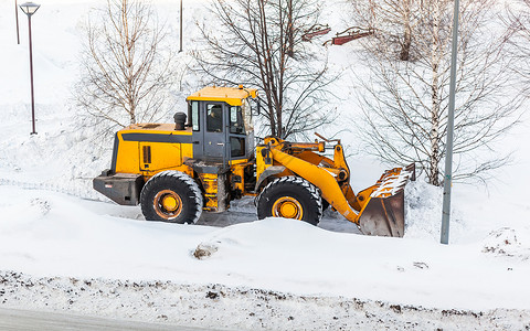 清理雪地 拖拉机在大雪降雪后扫清了道路司机工作橙子街道雪堆装载机城市服务打扫机器背景