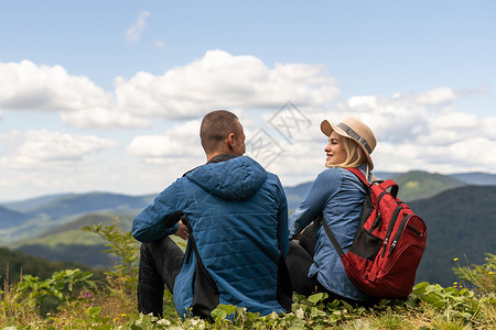 情侣旅行者男人和女人坐在放松的山上 观看爱情和旅行快乐的情感生活方式概念 旅行活跃冒险假期的年轻家庭山脉自由潮人男性娱乐友谊旅游背景图片
