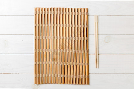 两片寿司筷子 空竹垫或木制背景面板的木板 影版结盘背景图片