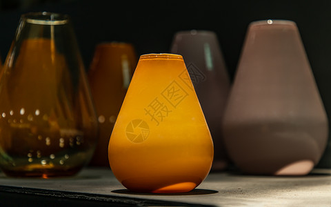 在玻璃软件仓库的架子上展示黄色玻璃花瓶物品器皿优雅风格阴影收藏装饰工厂反射团体背景图片