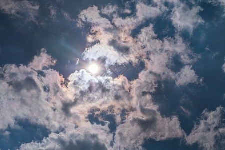 蓝天的烟云中 有阳光照耀的乌云太阳射线蓝色背景图片