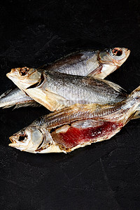整条和剥皮的盐咸空气钻过的蟑螂鱼 黑底有鱼子酱背景图片
