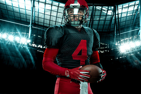 美国足球运动员的特写肖像 在大舞台背景上戴着红色头盔的运动员运动员 体育和动机壁纸大学竞赛男人男性赛跑者团队联盟运动游戏体育场背景图片