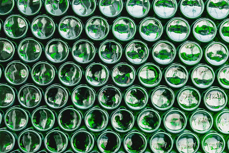 玻璃瓶绿色 绿色玻璃瓶啤酒 绿色瓶子形成的墙 绿色瓶背景 带照明的空玻璃瓶饮料圆圈圆形团体液体反射回收生产生态制造业背景图片