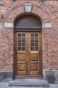 丹麦一家旧砖屋内有拱门的木制门背景图片