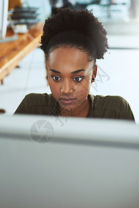 一位年轻女商务人士在现代办公室的电脑上工作 她的工作重心是完成她所有的最后期限背景图片