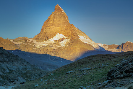 玛珈山日出时有金色光亮的马季斯蒂斯·卡蓬 瑞士阿尔卑斯山 泽尔玛特背景