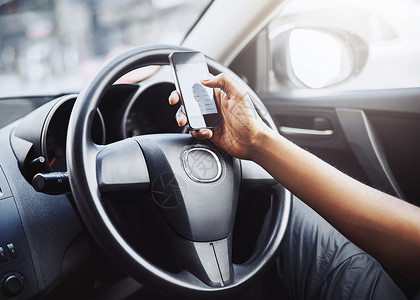 您的手机会分散您的注意力 一个面目全非的男人在开车时使用手机背景图片
