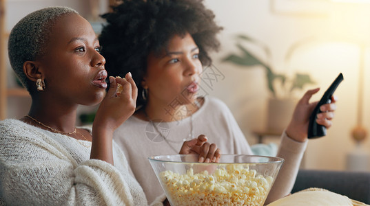 女人 电影或吃爆米花 在客厅里看电视节目或订阅系列 微笑 快乐或朋友在媒体电影中交谈 一起播放戏剧和娱乐节目背景图片
