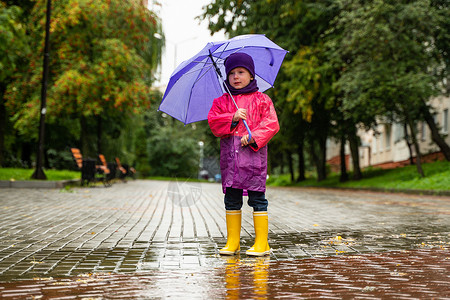 雨中行走孩子孩子在秋雨中玩耍 有伞的孩子 任何天气都能为孩子们带来户外乐趣 儿童雨衣 靴子和夹克衣服幸福季节雨滴家庭快乐婴儿童年女性背景