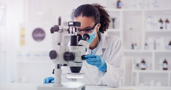 员工会素材她会发现什么新的突破 一个年轻科学家在实验室里 使用显微镜的背景