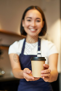 微笑的美如一家咖啡会女孩 给外送咖啡杯 准备请客餐饮的外卖订单 穿着围裙制服职场女性工作食堂广告酒吧房子命令服务员职业背景图片