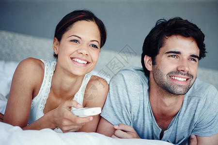 一对幸福的情侣躺在床上 一起看电视 被拍到了一张照片 笑声 掌声技术妻子卧室丈夫娱乐男朋友女朋友休闲女性快乐背景图片