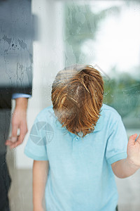 我想到外面去 一个年轻男孩在下雨时 头朝窗边看望着他的头背景图片