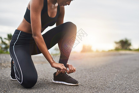 路与鞋素材一个运动的女性在户外锻炼时绑着鞋带的特拍镜头 近距离拍摄到最后背景