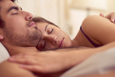 睡个好觉 快乐地醒来 一个爱的年轻夫妇一起睡在床上背景