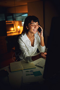 夜以继日地全力以赴 一个年轻的女商务人士在深夜工作时使用手机和电脑背景图片