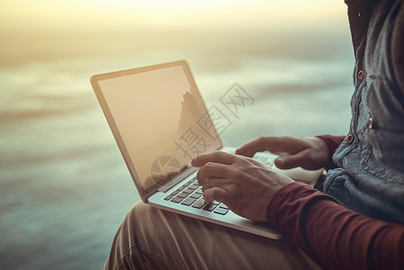 始终连接 一个面目全非的男人坐在山间的悬崖上使用笔记本电脑背景