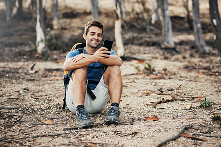 你去吧下回你应该一起来 一个快乐的年轻人在去山上登山的时候 用他的手机发短信呢背景