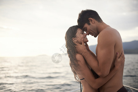 水假温柔的时刻 一个亲密的年轻夫妇 在日落时在海边度个假背景