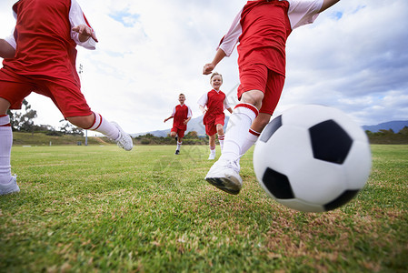 足球精神一起玩的同时学习团队精神 低角度的小孩 在田野上踢足球背景