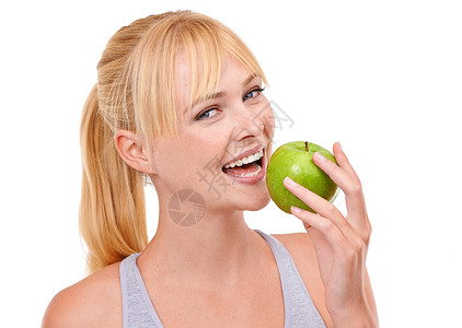 为他人着想为健康着想 工作室肖像画 一个迷人的年轻女人吃一个孤立在白色上的苹果背景