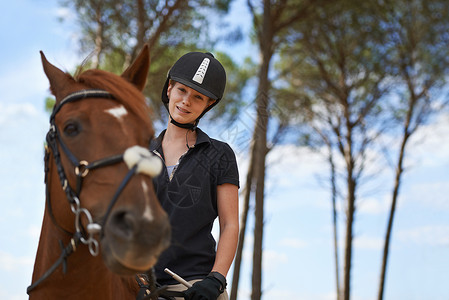 马术体验在马背上体验大自然 一位年轻女子骑着她的栗色马去兜风训练成人板栗马匹马术缰绳骑马女性动物女士背景