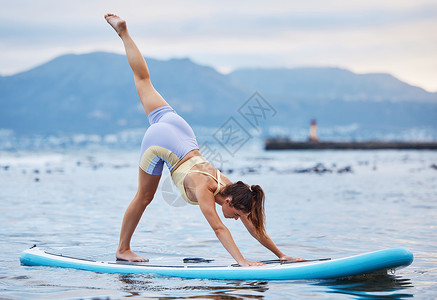水平衡女人 冲浪板或海洋或海上的水上瑜伽放松锻炼 训练或锻炼以实现核心平衡 健康或健康 自然健身或身体普拉提中桨板上的禅宗 平静或和平背景