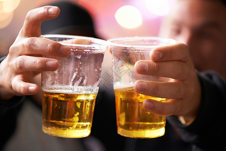 时光慢些吧喝吧 两个朋友为美好的时光敬酒 用塑料杯啤酒 -音乐节 来庆祝美好时光背景