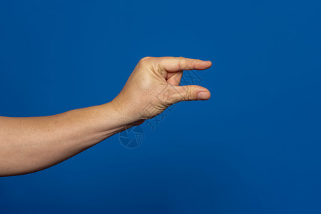 手指尺寸素材男性天主教徒手势 用两根手指显示小尺寸 在蓝色背景上隔开背景