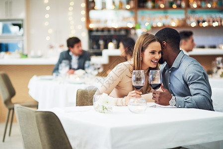 一个男人在餐桌上说出秘密的餐厅约会 情侣和葡萄酒庆祝活动 周年庆典 情人节微笑和夜晚的葡萄酒 充满爱 关怀和交谈背景图片