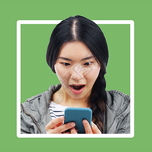 边框手机素材亚洲女人 哇 手机上有绿色背景的边框 看着移动文本 在线交流 数字新闻和年轻人在带 wifi 的手机上惊讶的震惊面孔背景