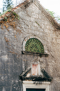 一座建筑的旧石墙 有一扇拱形窗户背景图片