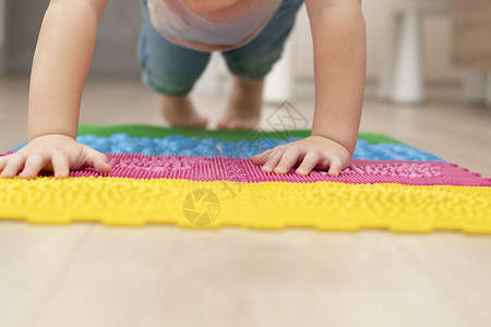 足外翻健康概念 一个小男孩站在木板上 在室内的整形按摩垫子上站稳了脚跟背景